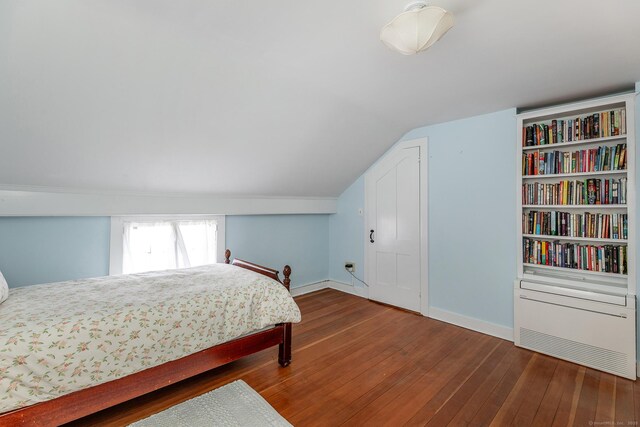 bedroom with hardwood / wood-style flooring, baseboards, and vaulted ceiling