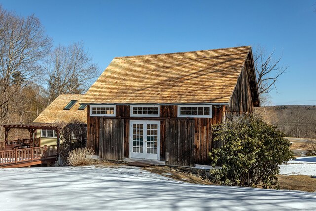 snow covered structure featuring french doors