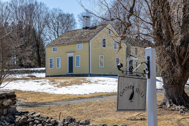 exterior space featuring a shingled roof and a chimney