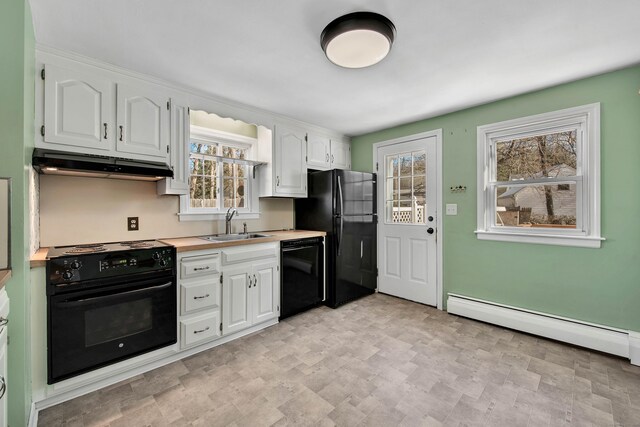 kitchen featuring white cabinetry, a wealth of natural light, baseboard heating, and black appliances