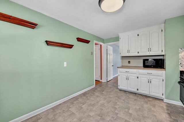 kitchen featuring white cabinets and black appliances