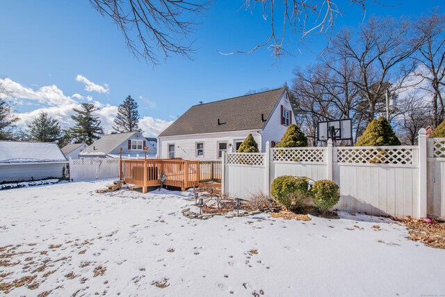 snow covered house featuring a deck