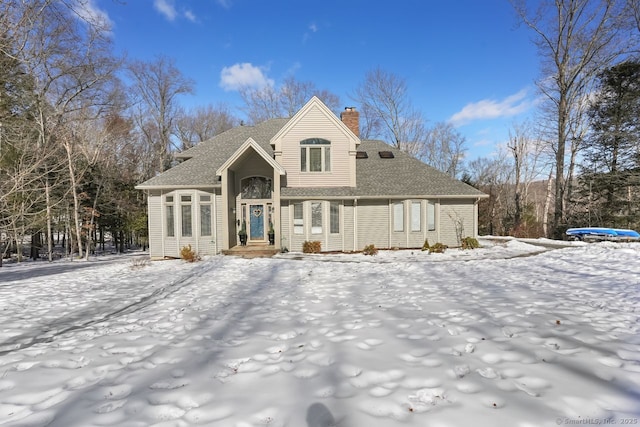 view of front of house with a chimney and a shingled roof