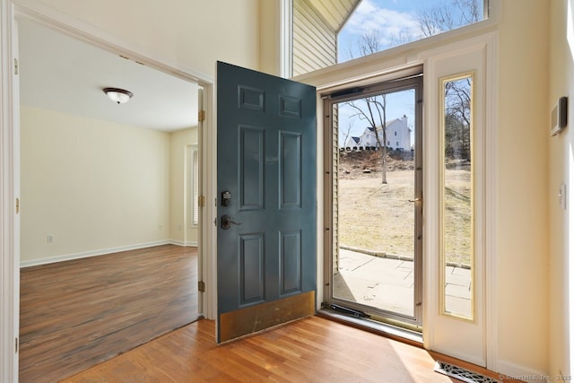 foyer entrance featuring visible vents, baseboards, and wood finished floors