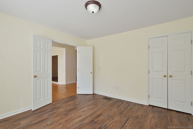 empty room featuring dark wood finished floors and baseboards