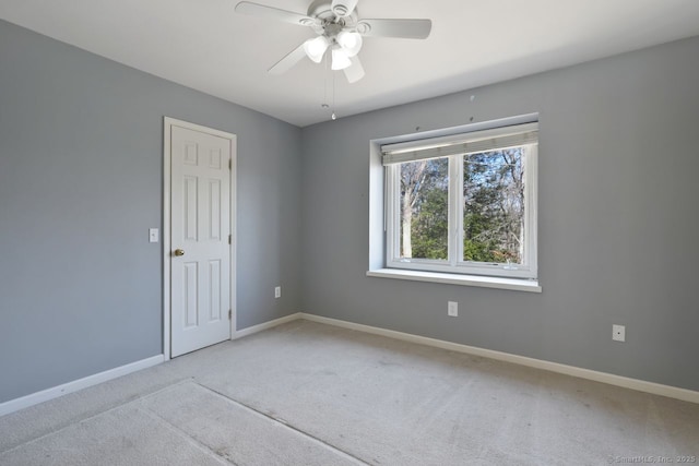 carpeted empty room featuring baseboards and ceiling fan