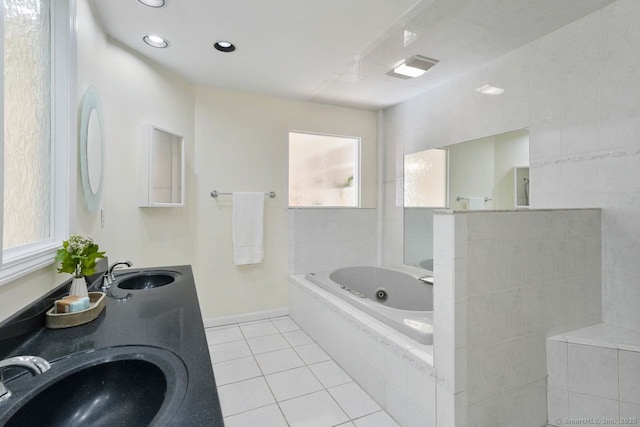 full bathroom featuring tile patterned flooring, a whirlpool tub, baseboards, and a sink