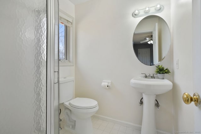 bathroom featuring a ceiling fan, baseboards, a sink, tile patterned floors, and toilet