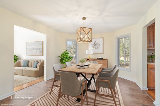 dining room featuring baseboards, an inviting chandelier, and wood finished floors