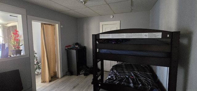 bedroom with light hardwood / wood-style flooring and a paneled ceiling