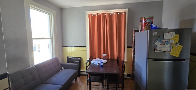 interior space with a baseboard radiator, dark hardwood / wood-style floors, and tile walls