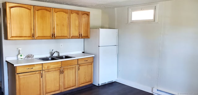 kitchen with sink, a baseboard radiator, a textured ceiling, and white fridge