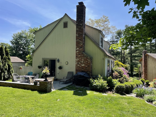 rear view of property featuring a patio and a lawn