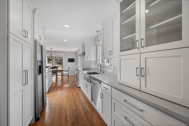 kitchen featuring white cabinetry, stainless steel appliances, and hanging light fixtures