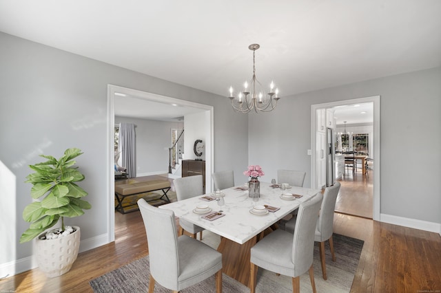 dining space featuring a notable chandelier and dark wood-type flooring