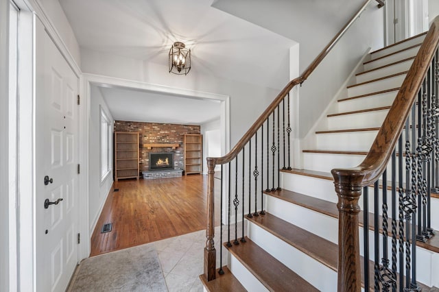 tiled foyer entrance with a brick fireplace