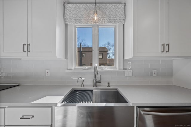 kitchen featuring white cabinetry, sink, hanging light fixtures, and dishwasher