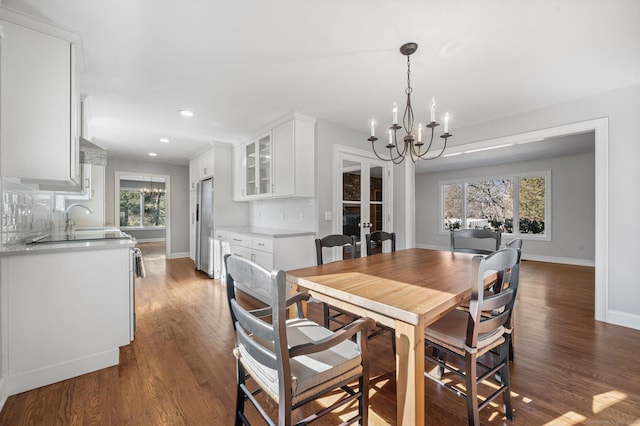 dining space with an inviting chandelier, dark hardwood / wood-style flooring, and sink