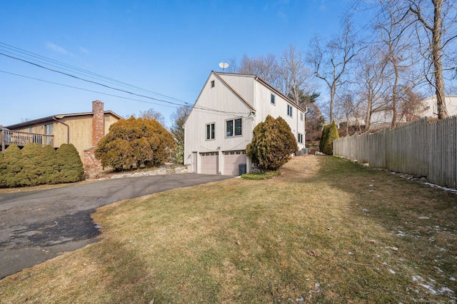 view of property exterior featuring a garage and a lawn