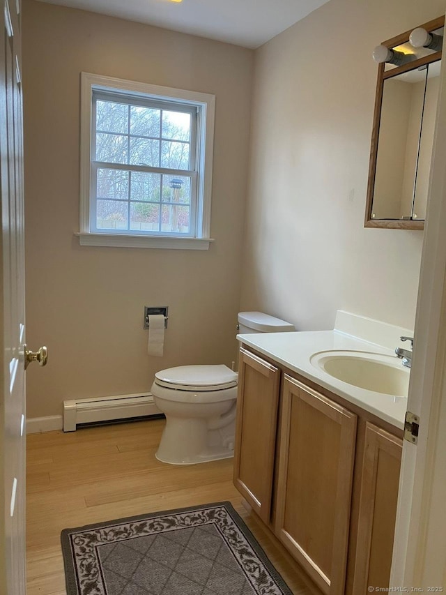 bathroom featuring a baseboard radiator, vanity, toilet, and hardwood / wood-style floors