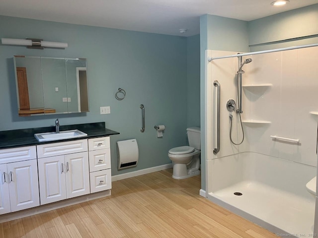 bathroom featuring vanity, hardwood / wood-style floors, toilet, and walk in shower