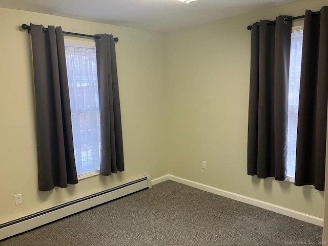 carpeted empty room with a baseboard heating unit