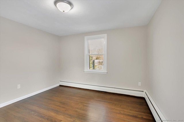 unfurnished room featuring dark hardwood / wood-style floors and baseboard heating