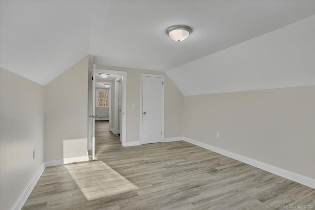 bonus room with baseboard heating, lofted ceiling, and light hardwood / wood-style flooring