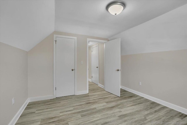 bonus room featuring lofted ceiling and light wood-type flooring