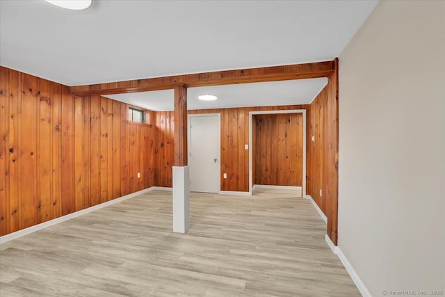 basement with wooden walls and light hardwood / wood-style flooring