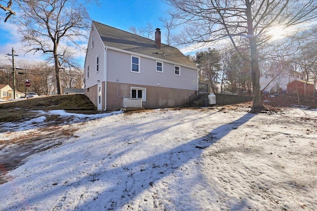 view of snow covered rear of property