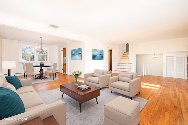 living room with an inviting chandelier and light hardwood / wood-style floors