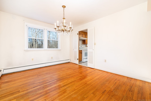 spare room with a baseboard heating unit, a notable chandelier, and light wood-type flooring