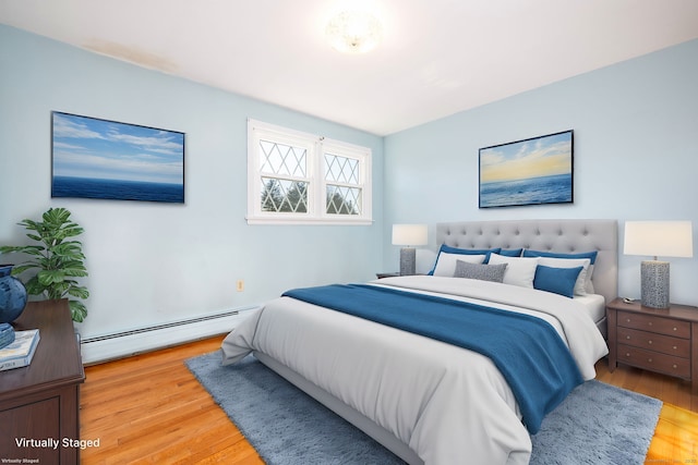 bedroom featuring baseboard heating and hardwood / wood-style floors