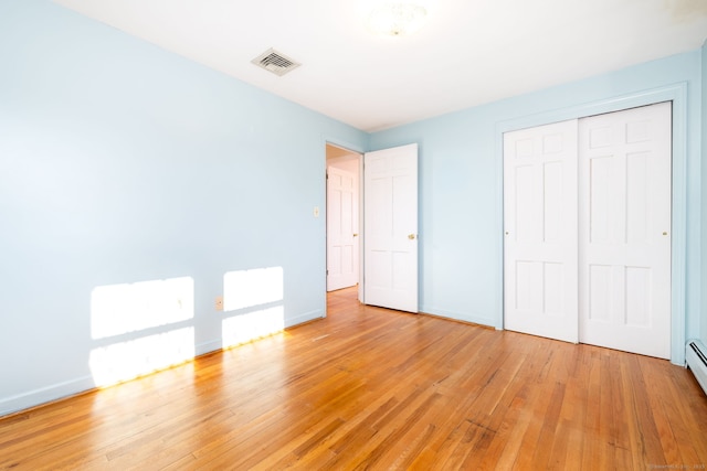 unfurnished bedroom with a closet and light wood-type flooring