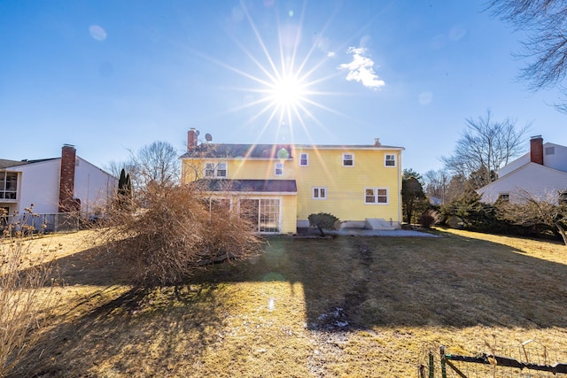 rear view of property with a yard