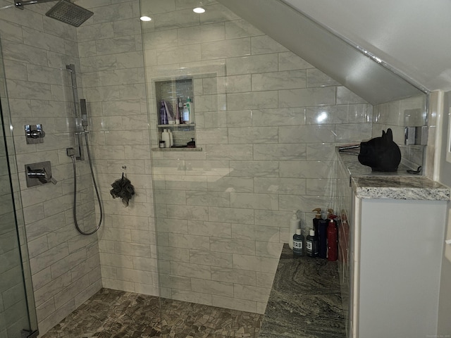bathroom with lofted ceiling and a tile shower