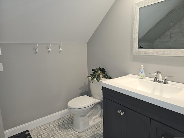 bathroom featuring vanity, vaulted ceiling, and toilet
