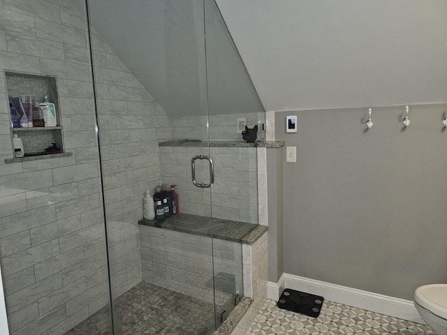 bathroom featuring lofted ceiling, a shower with shower door, and toilet
