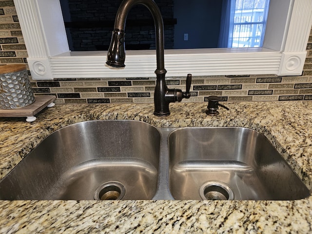 details featuring stone counters and sink