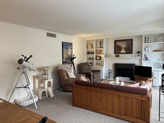 living room featuring built in shelves, carpet floors, and a textured ceiling