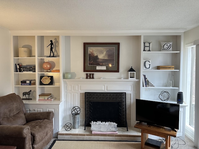 interior space with a textured ceiling, a fireplace with raised hearth, and built in features