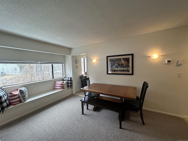 dining area featuring carpet floors, baseboards, and a textured ceiling