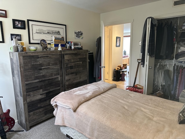 bedroom featuring light colored carpet and a closet