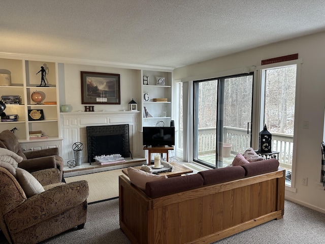 carpeted living area featuring a textured ceiling, a fireplace with raised hearth, and built in shelves