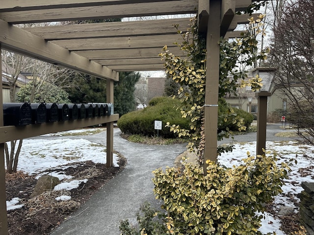 snow covered patio with a pergola