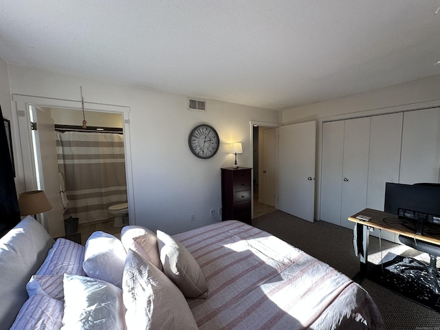 bedroom featuring connected bathroom, dark carpet, and a closet