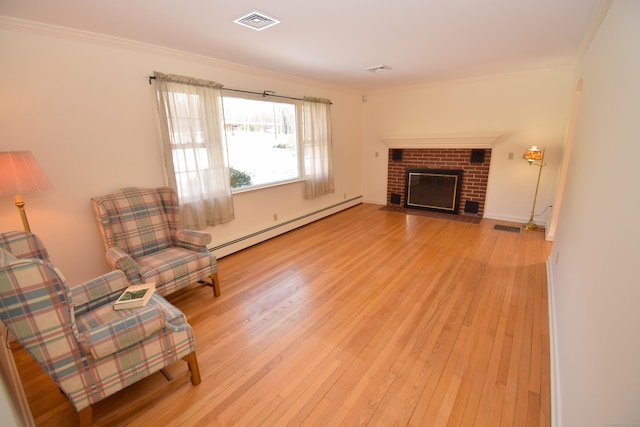 living area with baseboard heating, wood-type flooring, a fireplace, and crown molding