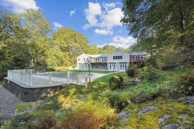 back of house with a swimming pool side deck and a patio