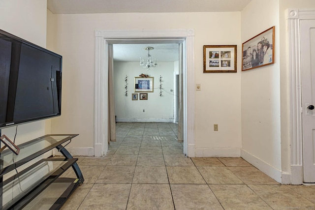 hallway with a notable chandelier and light tile patterned flooring